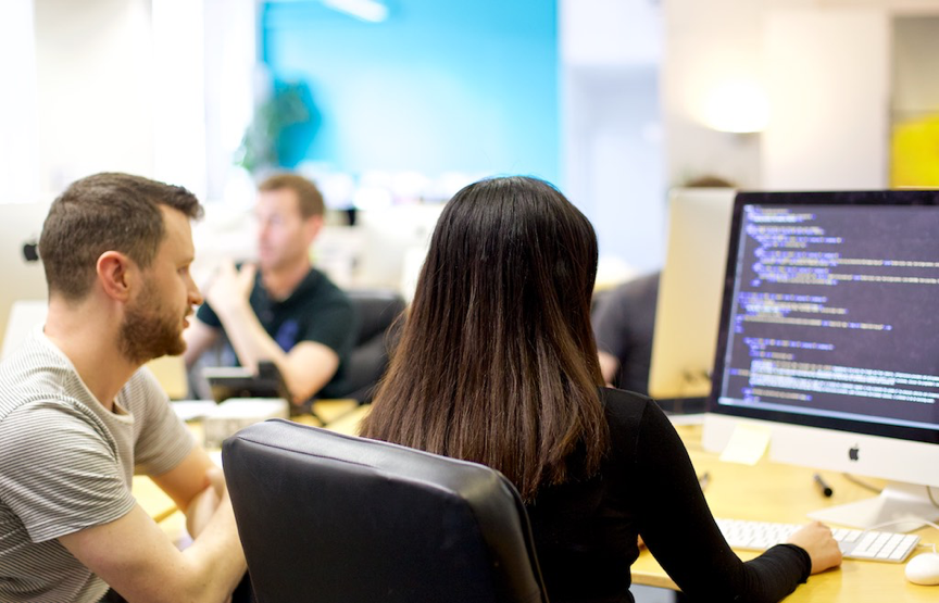 Pauline at a computer for her first internship wearing a black top